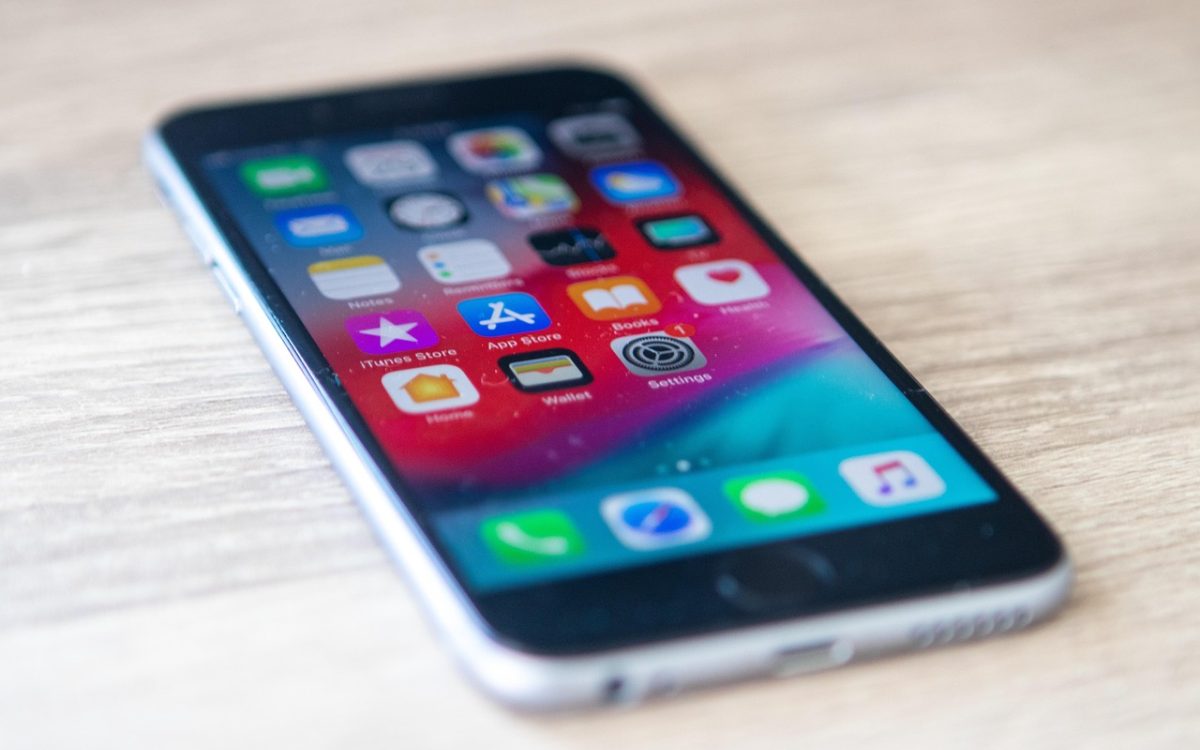 92 App 手机端主界面在浅木色桌面上的展示，屏幕里排列着分类片单与播放进度条，晨光从左侧斜照进来